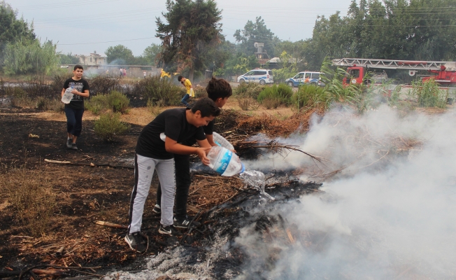 Çocuklar ellerindeki pet şişelerle yangını söndürmek için ekiplere yardım etti